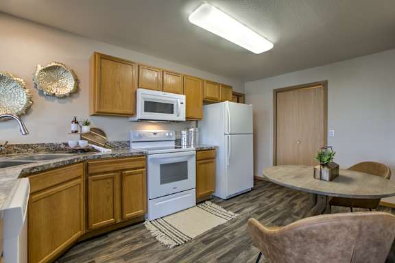 A kitchen with a white refrigerator, white microwave, and white oven. at Tranquility Pointe, Nebraska, 68164