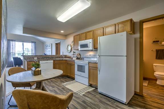 A white refrigerator is in a kitchen with wooden cabinets. at Tranquility Pointe, Omaha, NE, 68164