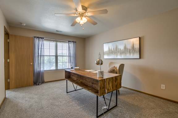 A room with a table and a chair in it. at Tranquility Pointe, Omaha