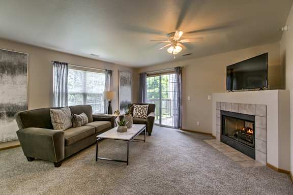 A living room with a fireplace and a television. at Tranquility Pointe, Omaha, NE