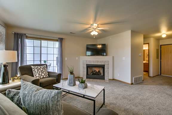 A living room with a fireplace and a flat screen TV. at Tranquility Pointe, Omaha, NE, 68164