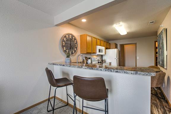 A kitchen with a marble countertop and two chairs. at Tranquility Pointe, Omaha, Nebraska
