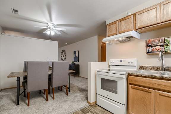A kitchen with a white oven and a fan on the ceiling. at The Pointe, LaVista, NE