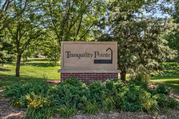 A sign that says Tranquility Pointe in black letters on a white background.