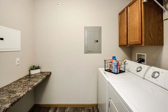 A laundry room with a washer and dryer, a counter, and a plant. at Standing Bear Lake, Nebraska, 68164