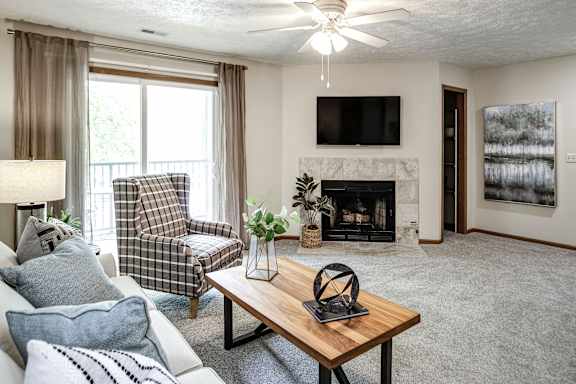 A living room with a fireplace and a television. at The Pointe, LaVista, Nebraska