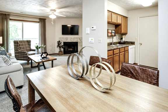 A modern dining room with a wooden table and chairs. at The Pointe, LaVista, Nebraska