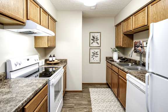 A kitchen with a white refrigerator, white stove, and white oven. at The Pointe, LaVista