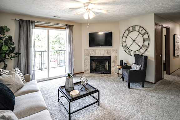 A living room with a fireplace at The Pointe, Nebraska