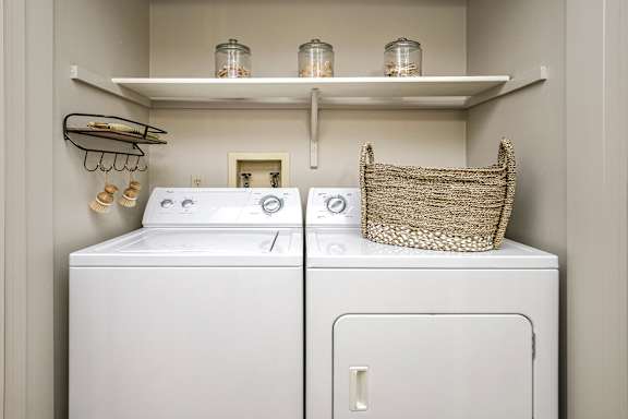 A white washer and dryer in a small laundry room. at The Pointe, LaVista, Nebraska