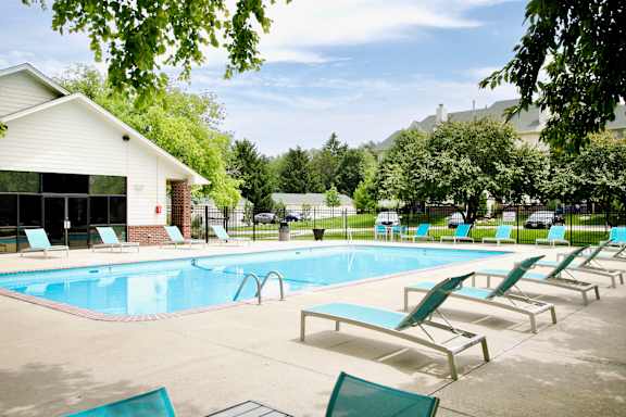 A pool with sun loungers and a building in the background. at The Pointe, LaVista