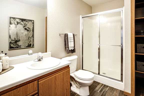 A bathroom with a toilet, sink, and shower. at Tranquility Pointe, Omaha