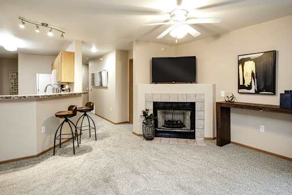 A living room with a fireplace and a television. at Tranquility Pointe, Omaha