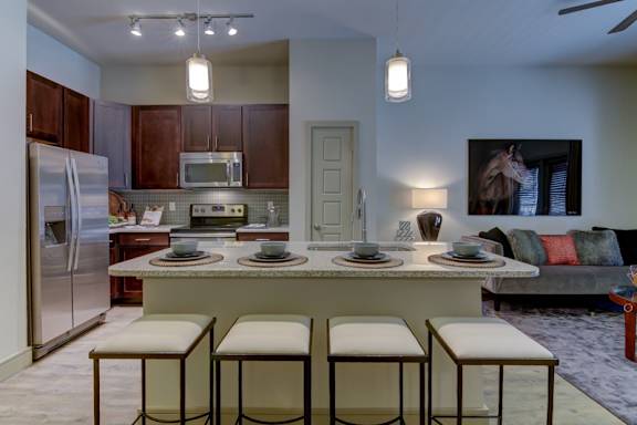 A kitchen with a table and chairs in front of it.