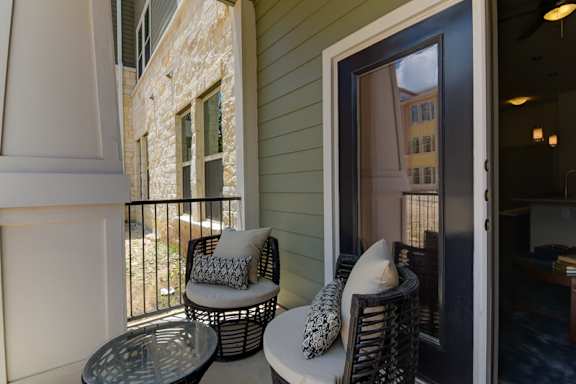 A balcony with a chair and a table.