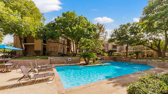 Outdoor pool with mature trees and patio furniture at Altamonte Apartments, San Antonio, 78216