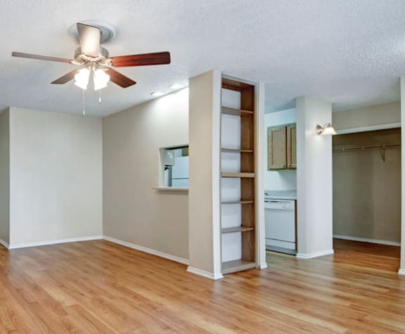 A room with a ceiling fan and wooden floors.