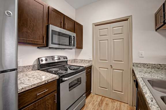 A kitchen with a stove, microwave, and oven.