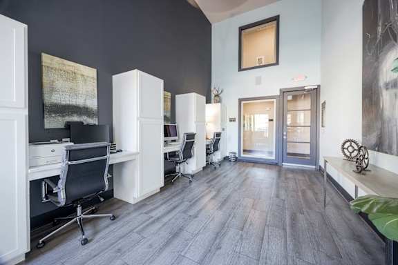 A room with a grey floor and white furniture.