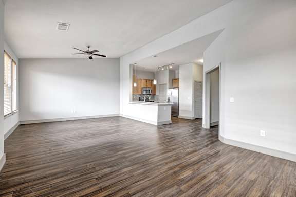 A room with wooden floors and a ceiling fan.