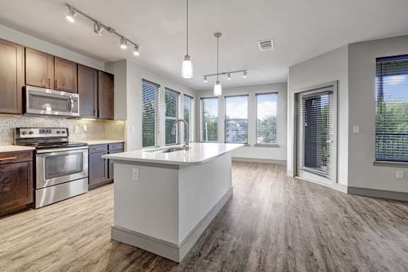 A modern kitchen with wooden cabinets and stainless steel appliances.