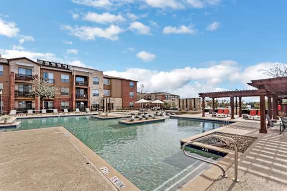 Swimming pool area with pergola and residential buildings at Gateway Cedars Apartments, Forney, Texas