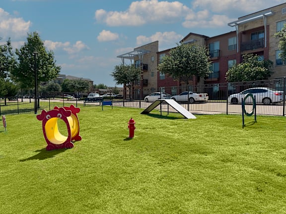 Dog park with agility equipment and play structures at Gateway Cedars Apartments, Texas