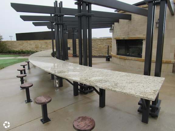 Outdoor dining area with fireplace and pergola at Gateway Cedars Apartments, Forney, TX
