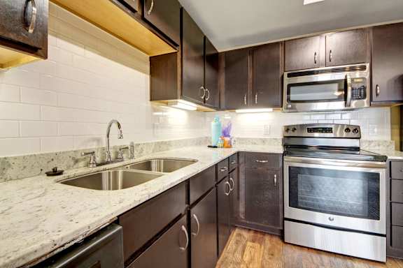 Updated kitchen with granite countertops and white subway tile at Gateway Cedars Apartments, Forney