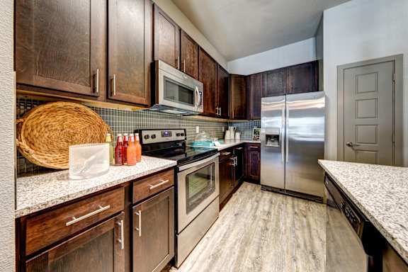 A kitchen with wooden cabinets and stainless steel appliances.