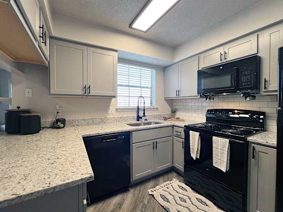 Kitchen with subway tile backsplash and granite counters at Ashwood Park Apartments, Dallas, 75252