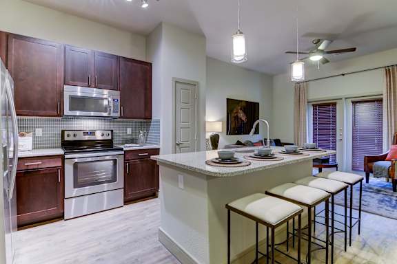 A kitchen with a white island and brown cabinets.