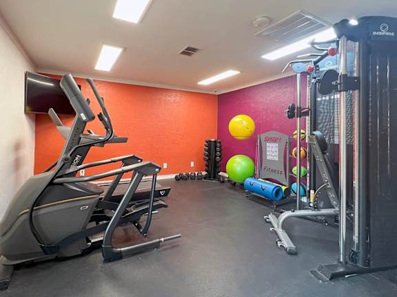 Fitness center with cable machine and exercise equipment at Autumn Chase Apartments, Texas