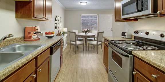 A kitchen with a stove top oven and a microwave above it.