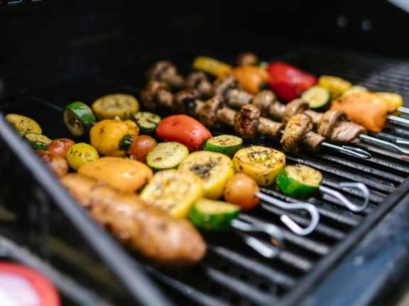 Grilled vegetables and meat skewers on outdoor grill at Autumn Chase Apartments, San Marcos, TX 78666