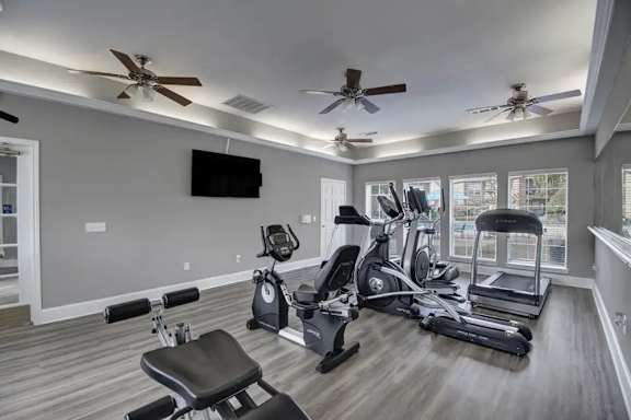 Fitness center with cardio equipment and ceiling fans at Indian Creek Apartments, Waxahachie