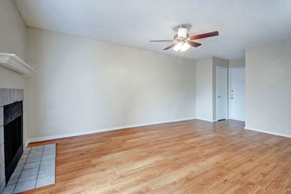 A room with a fireplace and a ceiling fan.