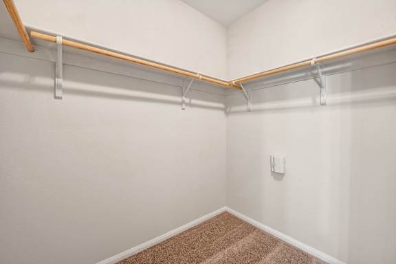 A white wall with a brown carpet and a white switch.