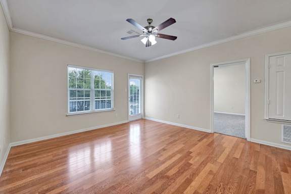 A room with a ceiling fan and wooden flooring.