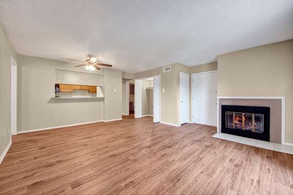 A living room with a fireplace and a ceiling fan.