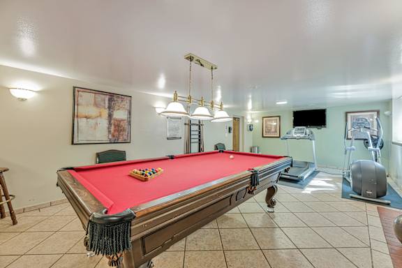 A pool table with a red cloth and a set of pool balls on it.