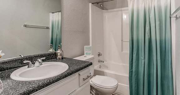 A bathroom with a sink, toilet, and shower.