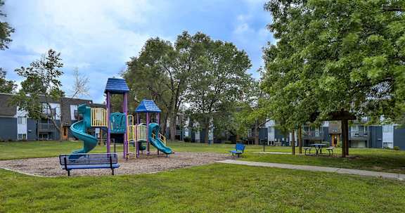 A playground with a green slide and a blue roof.