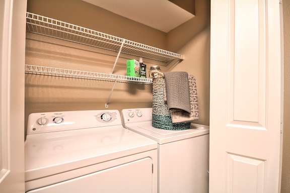 A white washing machine and dryer in a small laundry room at Rosemeade Apartments, Roseville, 95661