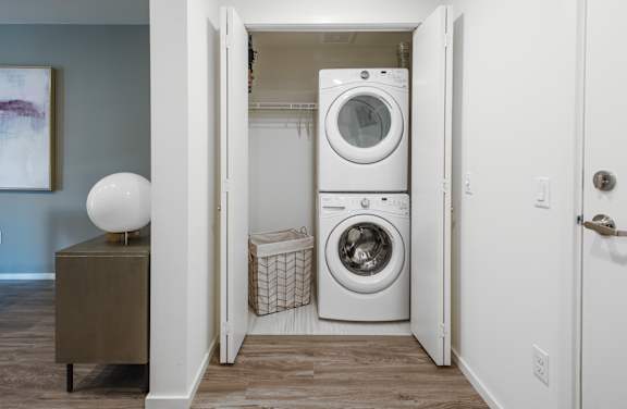 A laundry room with a washer and dryer stacked on top of each other.