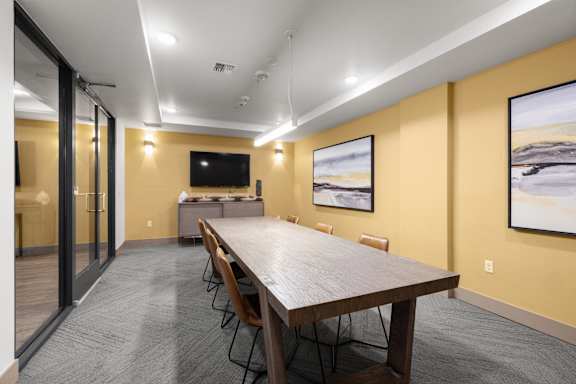 A conference room with a long table and chairs.