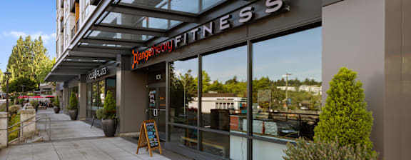 A fitness store with a glass front and a sign that says "Orange Fitness".