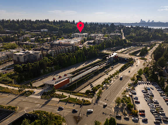 A red pin marks a location on a map of a city with a highway and buildings.