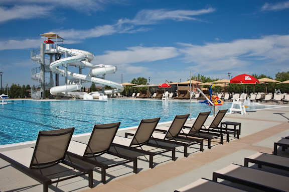 A pool with a water slide and lounge chairs at Rosemeade Apartments, Roseville, 95661