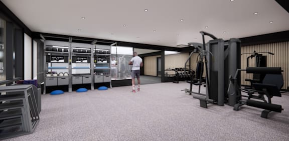 A man is standing in a gym with a variety of equipment.